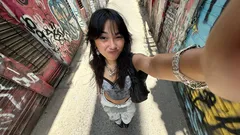 Young woman taking selfie in colorful graffiti alley in Philippines