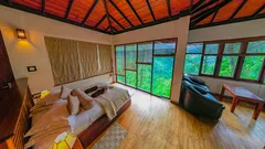 Cozy bedroom with large windows and nature view in a wooden cabin
