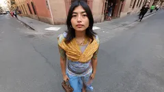 Young woman wearing scarf and jeans standing on city street corner